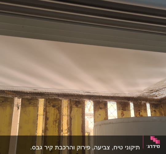 רשת מתכת על קיר צבוע ולוחות צהובים
